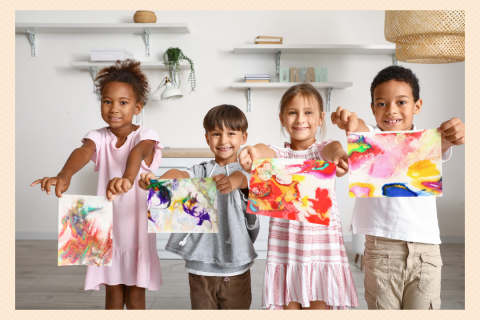 Kids holding up paintings.