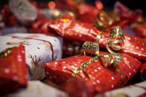 Image is a photo of red and white wrapped christmas presents with gold ribbon.