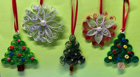 Row of white snowflakes and green Christmas trees made of paper strips.