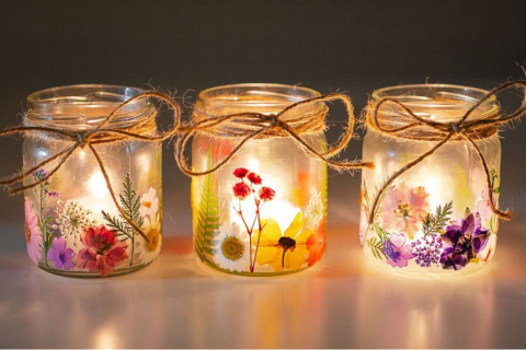 Three glowing lanterns with pressed flowers on the outside. 