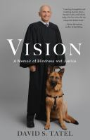 Image of tall man wearing black judge's robes with a German Shepherd guide dog at his feet