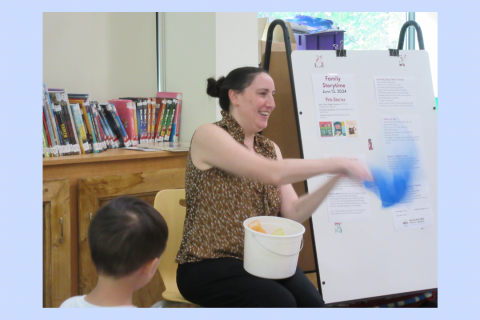A teacher singing a song with scarves.
