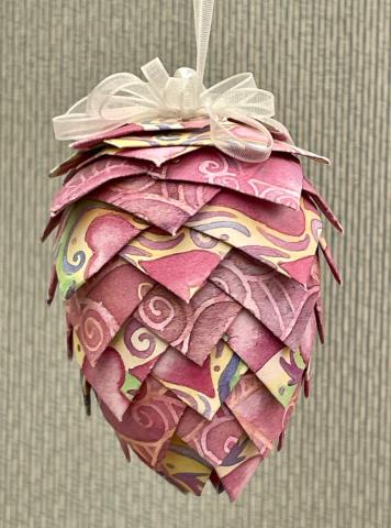 Pine cone ornament made of folded paper and pins