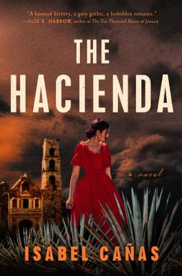 Image is the cover of the book "The Hacienda" by Isabel Canas. It shows a moody orange sky and a woman in a red dress standing in front of a Spanish style mansion.