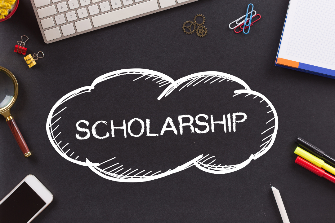 the word scholarship in a cloud shaped outline with school supplies surrounding. 